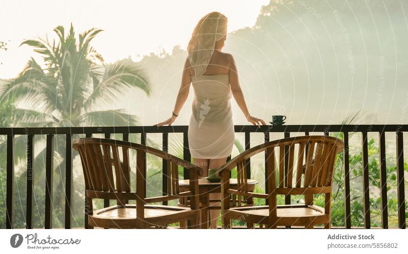 Frau genießt den Morgen auf einem tropischen Balkon Landschaft Gelassenheit Kaffee Handtuch hölzern Tisch mit Blick auf üppig (Wuchs) Tasse Natur im Freien