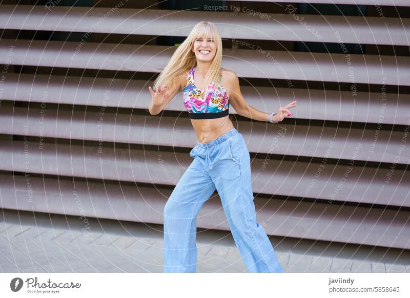 Blonde Frau tanzt auf der Straße Kaukasier jung Tanzen freudig energetisch pulsierend glückselig strahlend sorgenfrei Überschwänglich schwungvoll lebhaft