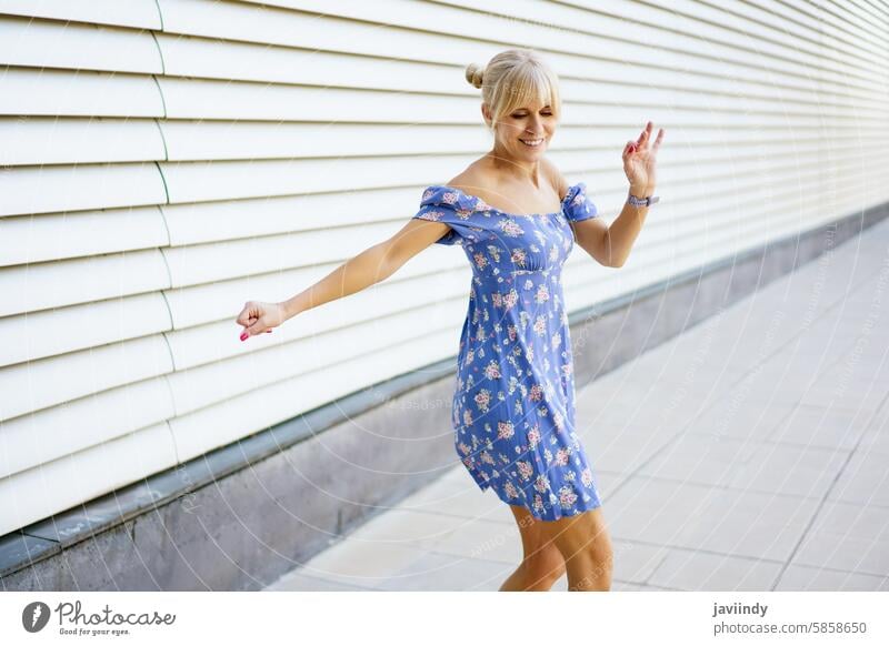 Sinnliche Frau im Sommerkleid tanzt Musik in der Stadt sinnlich blond Kleid Tanzen Glück modern Großstadt urban freudig energetisch stylisch Mode Bewegung