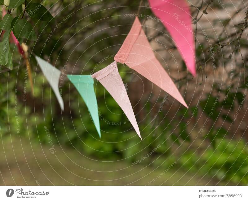 bunte Wimpelkette in pastellfarben draussen hängend wimpel wimpelkette feier party dreiecke dreieick form förmig geometrische figur grün rosa pink grün draußen