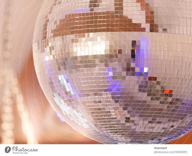Diskokugel in Nahaufnahme mit Lichtreflexen in Lila discokugel disko ball rund anschnitt nahaufnahme detailaufnahme mosaik spiegelungen kleine vierecke quadrate