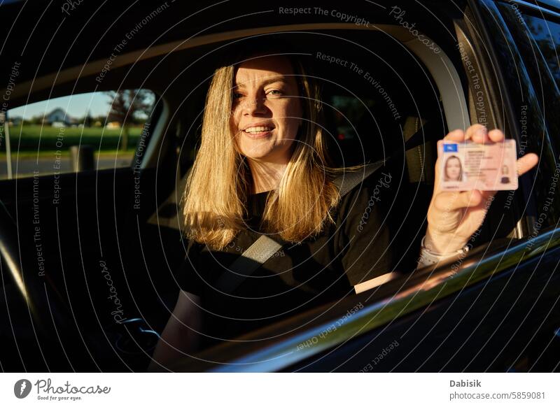 Glückliche Frau hält Führerschein im Auto fahren Lizenz PKW Fahrer Beteiligung positiv Schriftstück Prüfung Fahrzeug Sicherheit Sonnenuntergang Sitz Freude
