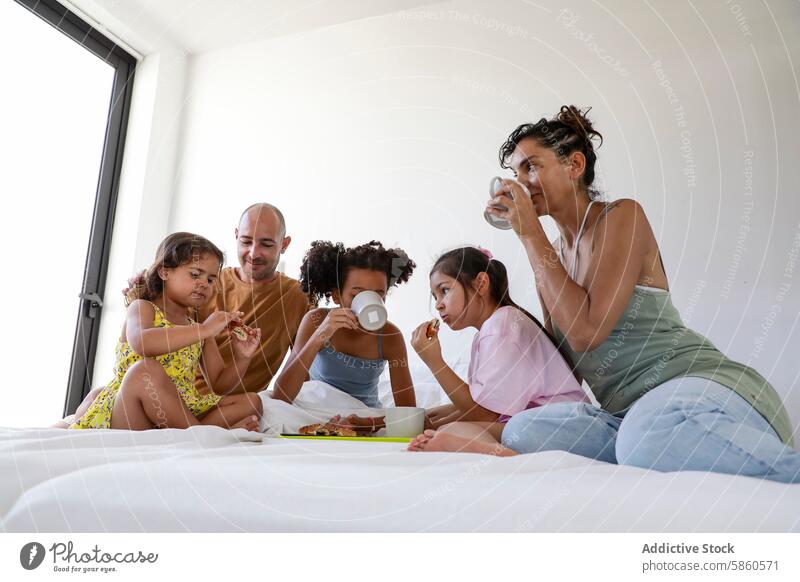 Multiethnische Familie beim gemeinsamen Frühstück im Bett multiethnisch Kinder Morgen Essen trinken Glück gemütlich Schlafzimmer Sonnenlicht Zusammensein