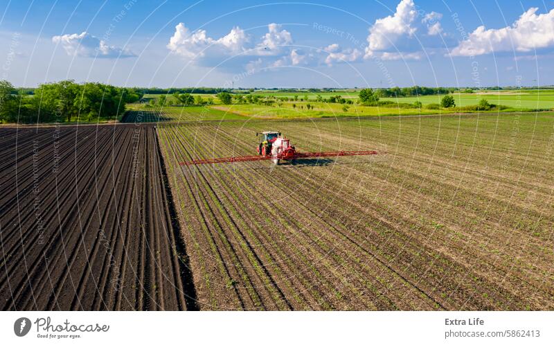 Luftaufnahme eines Traktors beim Besprühen eines Feldes mit Sprühgerät, Herbizid und Pestizid oben Aerosol landwirtschaftlich Ackerbau anbaufähig biochemisch