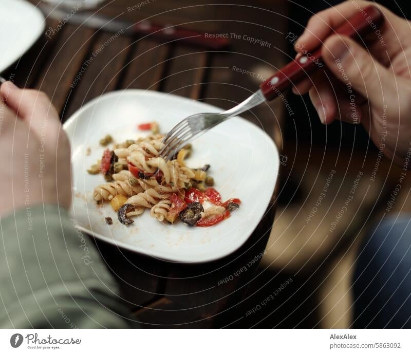 [HH Schregatour24] Weißer Teller mit italienisch anmutenden Spirelli- Salat, der gerade mit einer Gabel von einem Mann gegessen wird weißer Teller Geschirr