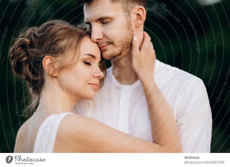 Mädchen in einem weißen Sommerkleid und ein Mann in einem weißen Hemd bei einem Spaziergang bei Sonnenuntergang mit einem Blumenstrauß braun Tag Erde Wald