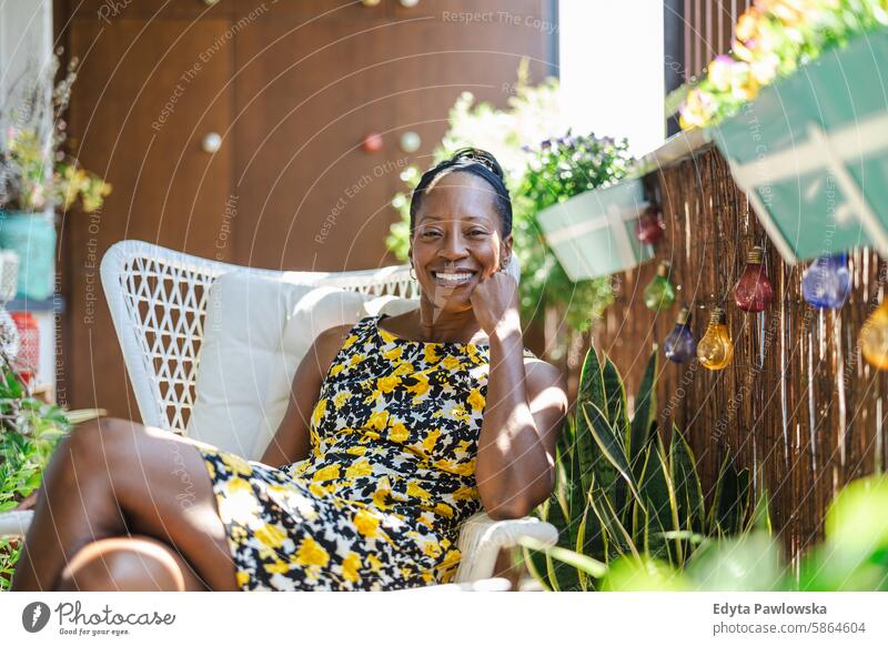 Schöne Frau entspannt sich auf dem Balkon zu Hause Menschen Freude schwarz natürlich attraktiv schwarze Frau Fröhlichkeit Glück echte Menschen reif Erwachsener