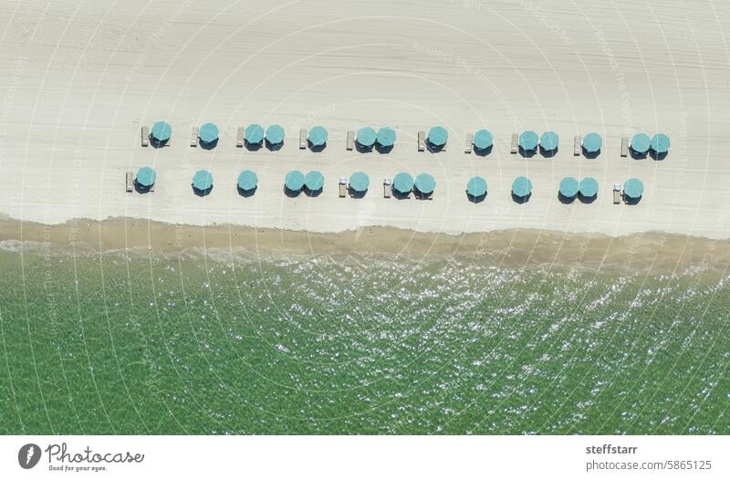 Hellblaue Sonnenschirme aus einer Drohne über einem Strand blauer Sonnenschirm Küste MEER Meer Florida grünes Wasser klares Wasser Küstenstreifen Landschaft