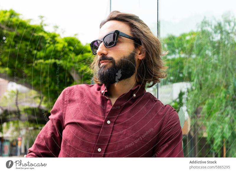 Stylischer Mann in Poblenou mit Sonnenbrille und kastanienbraunem Hemd Mode kastanienbraunes Hemd poblenou Barcelona Lifestyle Vollbart lange Haare Stil jung