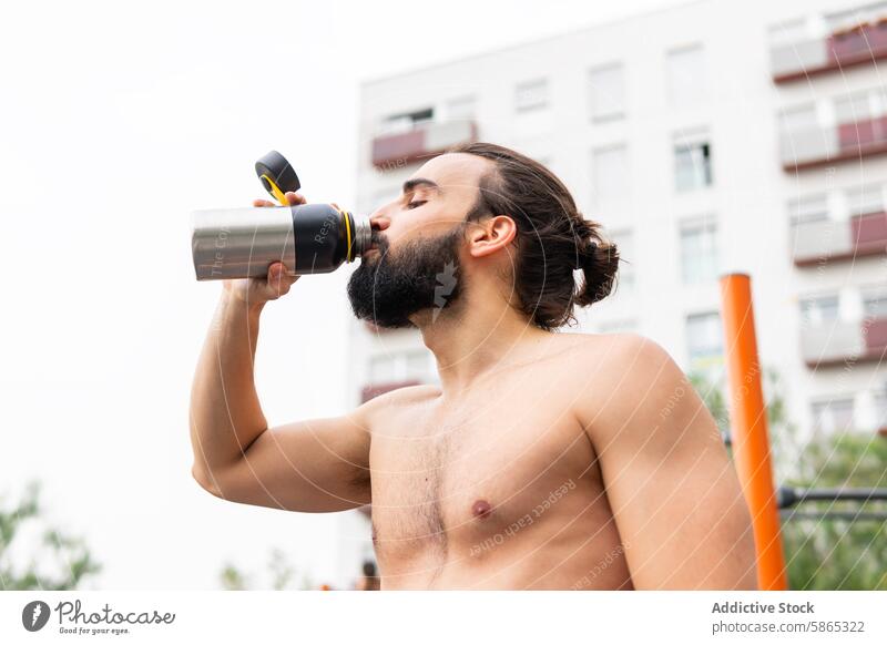 Mann trinkt nach dem Training in Poblenou, Barcelona Wasserflasche trinken im Freien Übung Vollbart Hydratation Fitness poblenou Lifestyle Gesundheit muskulös