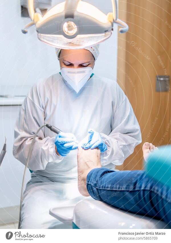 Fußpflegerin bei der Fußpflege in ihrer Fußpflegepraxis. Selektiver Fokus Frau Gesundheit Klinik nageln Arzt Podologe Ballenzeh callus medizinisch geduldig