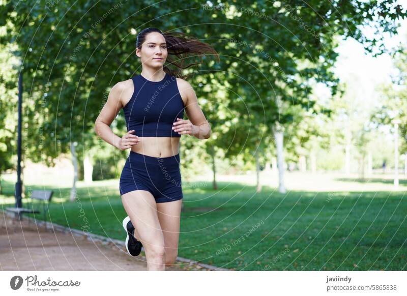 Junge Frau beim Joggen im Freien, die in Sportkleidung für Fitness und einen gesunden Lebensstil wirbt, der Vitalität und Wohlbefinden widerspiegelt aktiv
