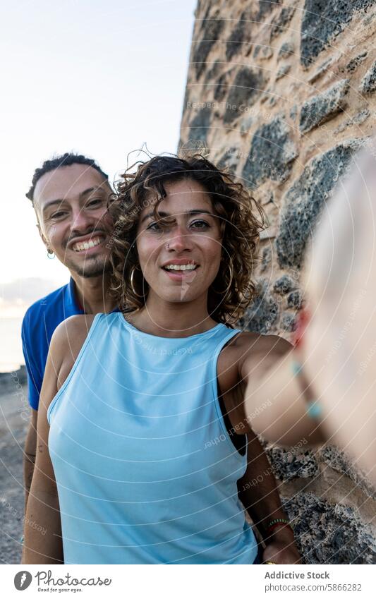 Selfie eines fröhlichen Paares an einer Steinmauer in Nahaufnahme Lächeln Fotokamera Freude Fröhlichkeit Steinwand Frau Mann Rastalocken Direkter Blick