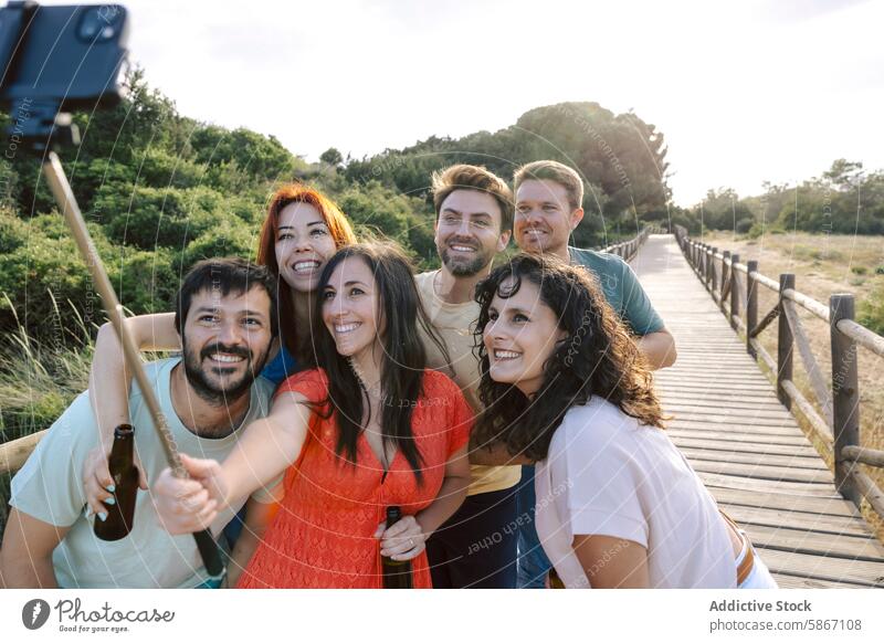 Eine Gruppe von Freunden genießt ein Bier auf einem Holzsteg Selfie im Freien Holzpfad Menschengruppe Freude lässig Nachmittag Natur sozial Sammeln Bonden