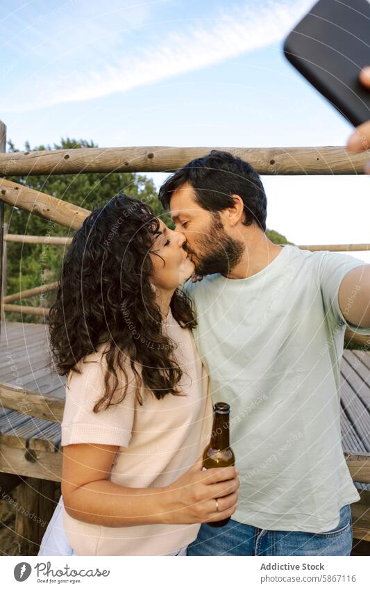 Paar, das sich küsst und ein Selfie mit Bier im Freien macht Kuss romantisch lässig Moment Intimität bewaldet Schiffsdeck Partnerschaft Liebe Umarmen Mobile