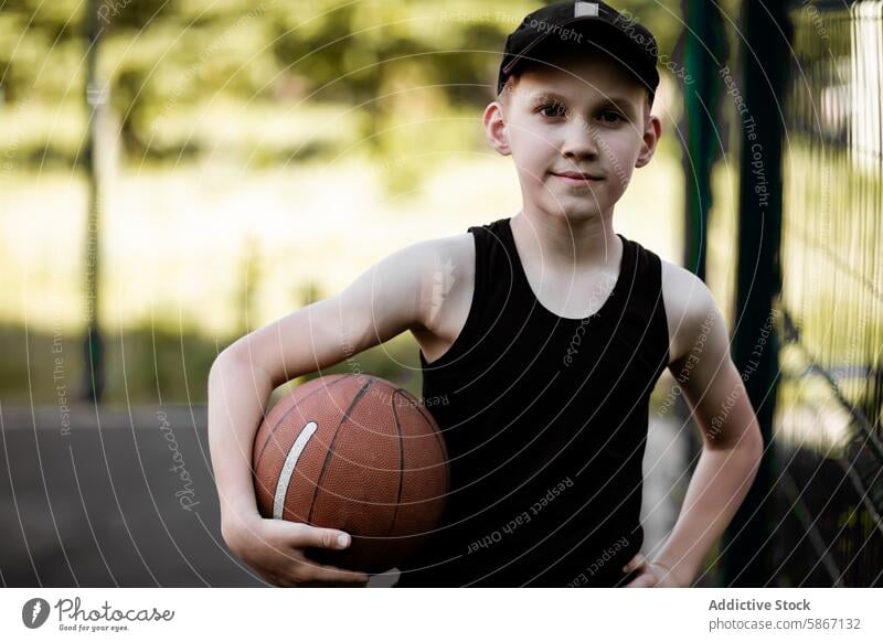 Kleiner Junge spielt im Sommer im Freien Basketball Teenager Sport Jugend sportlich Pose Ball Gericht grün Hintergrund verschwommen Selbstvertrauen Moment