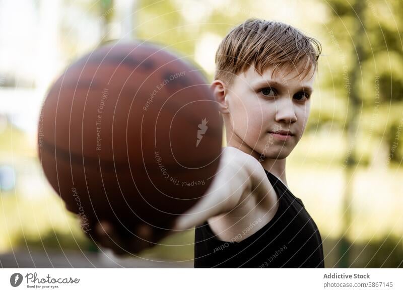 Teenager streckt einen Basketball in Richtung der Kamera Sport Ball Hand Fokus Fähigkeit Leidenschaft jung männlich im Freien Spiel spielen sportlich aktiv