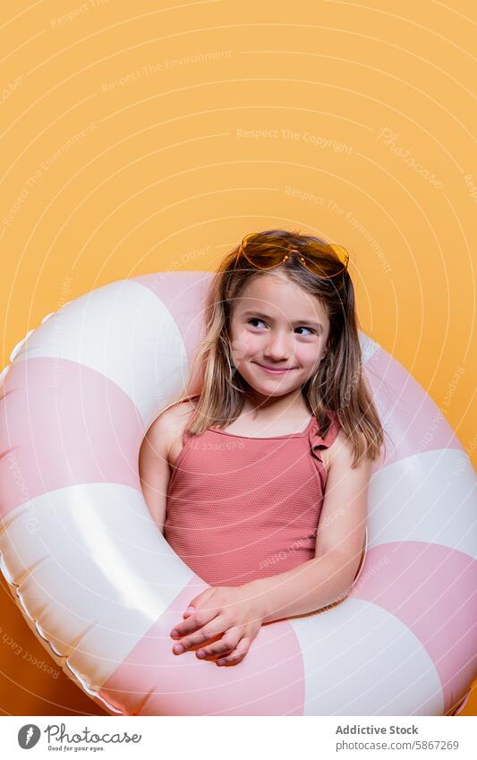 Mädchen im Sommer Thema mit aufblasbaren Ring im Studio Atelier orange Hintergrund Sonnenbrille Kleid Lächeln Freude Kind sonnig Foto Porträt Glück spielerisch