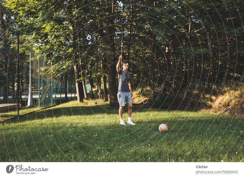Ein schwarzhaariger Sportler spielt ein freundschaftliches Fußballspiel auf dem Rasen. Amateursport. Mann spielt mit einem Ball. Dribbling-Übung. Sportlicher Lebensstil