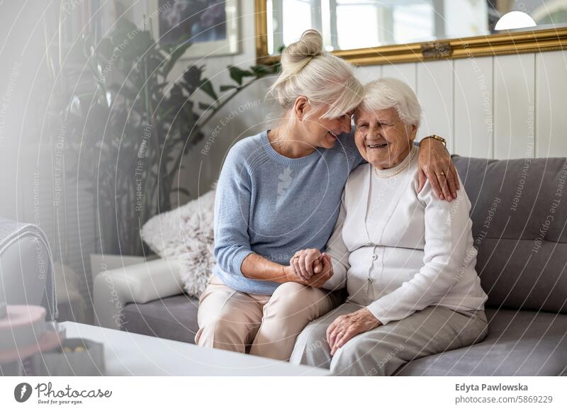 Glückliche ältere Frau mit ihrer erwachsenen Tochter zu Hause Lächeln genießend positiv Freude zufrieden Menschen Senior reif heimwärts alt Alterung