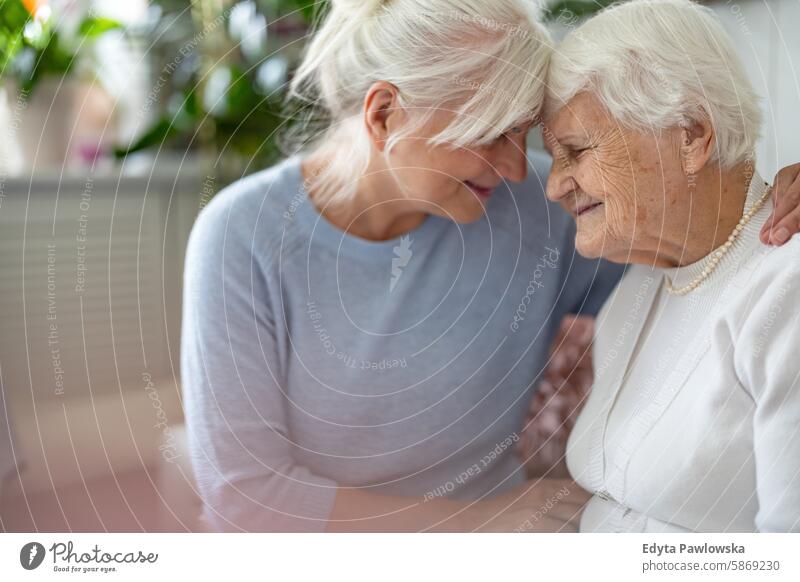 Glückliche ältere Frau mit ihrer erwachsenen Tochter zu Hause Lächeln genießend positiv Freude zufrieden Menschen Senior reif heimwärts alt Alterung