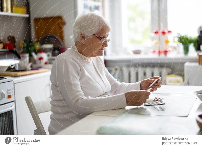 Ältere Frau nimmt Tabletten in der heimischen Küche Menschen Senior reif älter heimwärts Haus alt Alterung häusliches Leben Großmutter Rentnerin