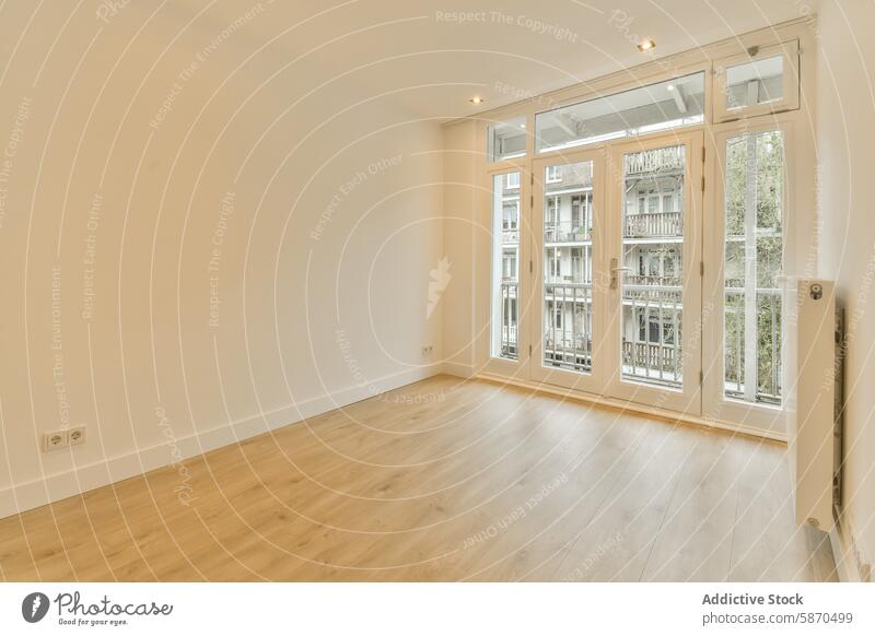 Ein Wohnzimmer mit Holzböden und einem großen Fenster Appartement modern Innenbereich hell hölzern Stock neutral Wand Raum geräumig kanaalstraat Niederlande