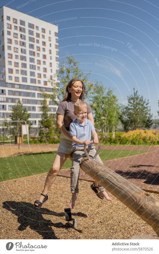 Mutter und kleiner Sohn genießen eine Wippe im Park Sommer Freude Lächeln Familie spielen im Freien sonnig Freizeit Kindererziehung Frau Junge Aktivität