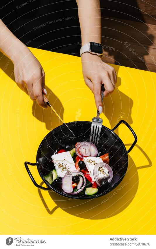 Hände, die einen frischen griechischen Salat in einer Pfanne im Freien zubereiten Salatbeilage Griechen Gesundheit Essen Mahlzeit Vorbereitung Diät Ernährung