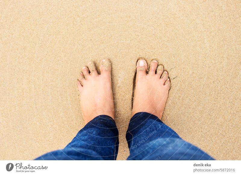 Draufsicht auf ein Mädchen, das eine Jeans trägt und barfuß auf braunem Strandsand steht Barfuß Seeküste Beine Fuß Hawaii sorgenfrei Genuss Fotografie nass Ufer