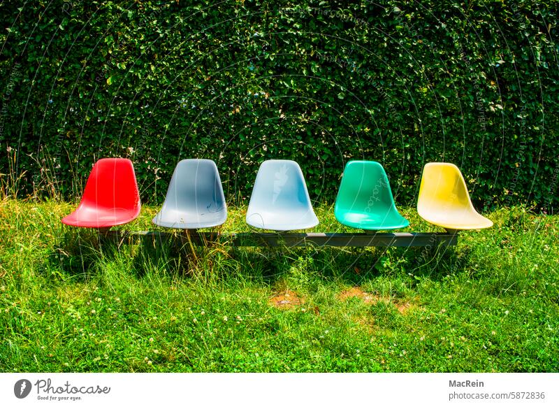 Fünf Designerstühle einer Gartenanlage sitze sitzreihe farbig aussenaufnahme menschenleer niemand