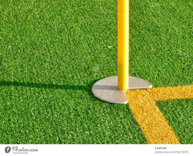 Das Runde muss ins Eckige Eckfahne Fußball Fußballplatz Fußballfeld Markierungen Markierungslinie Ecke eckig rund grün gelb Ballsport Sportrasen Schatten