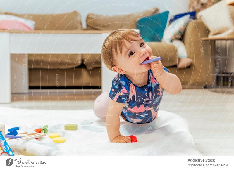 Kleinkind spielt mit buntem Spielzeug auf dem Boden im Wohnzimmer spielen heimwärts Teppich farbenfroh Kind Familie im Innenbereich Freude Fröhlichkeit