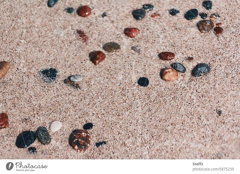 Steine im Strandsand bunte Steine Ostseestrand Meeresstrand Sand Sandkörner Strandsteine Meeressteine beige Beigefarben nass warmer Sand Steine am Strand