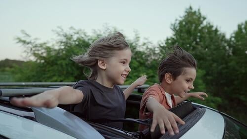 Funny Happy Little Boys steht in offenen Auto Schiebedach während der Reise, Summer.Childhood Erwachsener Air erstaunlich Waffen Junge Jungen Atmung PKW