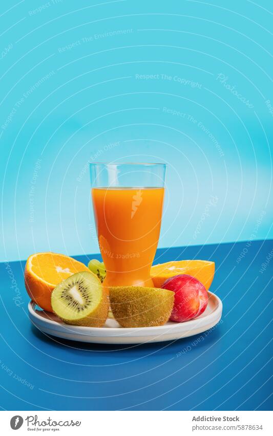 Bunter Fruchtaufstrich mit Saft auf leuchtend blauem Hintergrund orange Kiwi Glas Teller frisch farbenfroh pulsierend Snack Gesundheit Zitrusfrüchte Frühstück