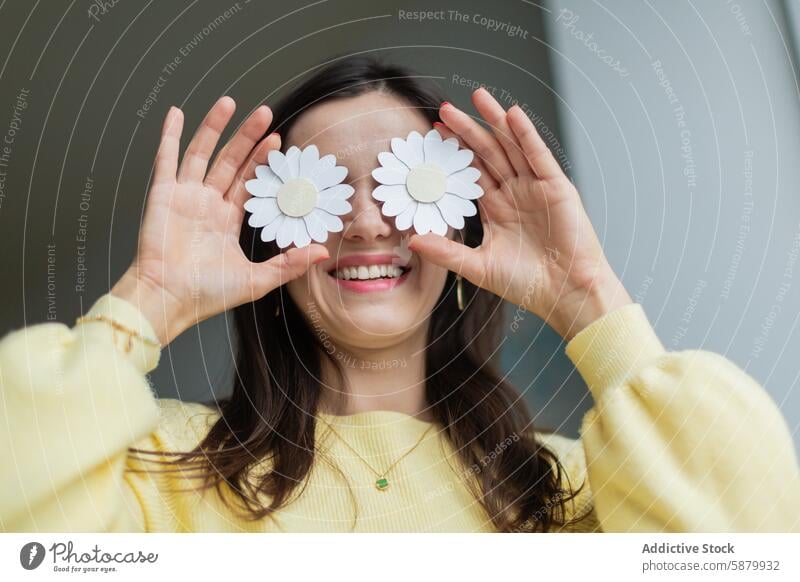 Junge Frau hält Papierblumen über ihre Augen Handwerk Blume Gänseblümchen kreativ handgefertigt Freude Lächeln jung Basteln Kunst Hobby Freizeit Aktivität