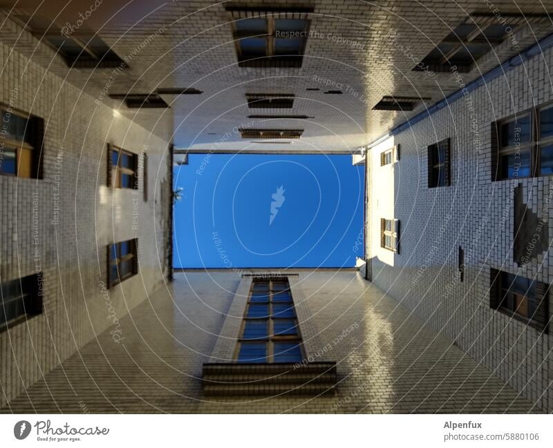 ein Stück blauer Himmel von einem Innenhof aus gesehen Froschperspektive Fassade Fenster Stadt himmelblau wohnhaus stadt Blick nach oben fassade wand innenhof