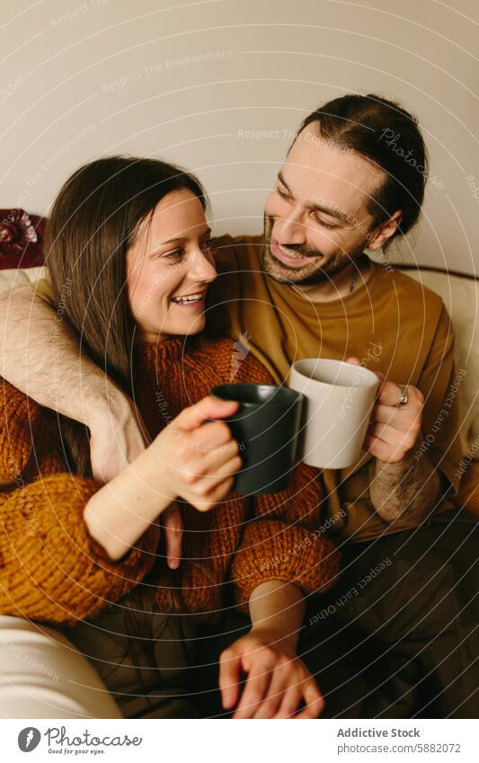 Zärtliches Paar, das einen gemütlichen Moment auf einem Sofa verbringt Zuneigung Liebe Starrer Blick itim Frau Mann Kaukasier Pullover Herbst Winter Hand