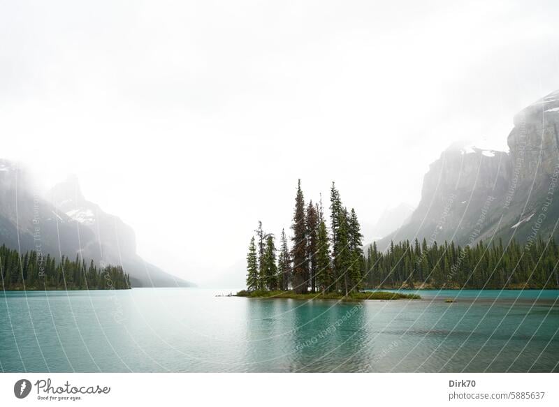 Spirit Island im Maligne Lake bei Jasper, Alberta, Kanada Insel Bäume Nadelbäume Berge u. Gebirge Dunst grauer Himmel Felsen weite Rocky Mountains Landschaft