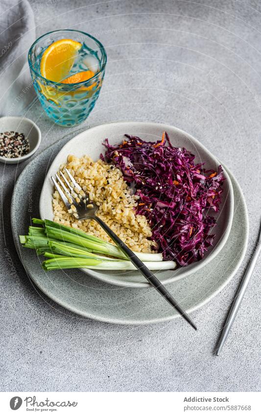 Gesundes Mittagessen mit Rotkohlsalat und gekochtem Bulgur Mahlzeit Gesundheit Ernährung Möhre Salatbeilage bulgur Teller Keramik grau Frühlingszwiebel frisch