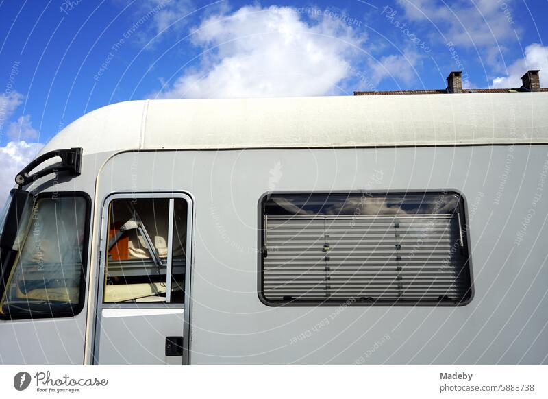 Bis ganz oben vollgepacktes modernes großes Wohnmobil der Luxusklasse mit Hochdach und Jalousie In Hellgrau auf einem Hof im Gewerbegebiet bei Sonnenschein in Detmold in Ostwestfalen-Lippe