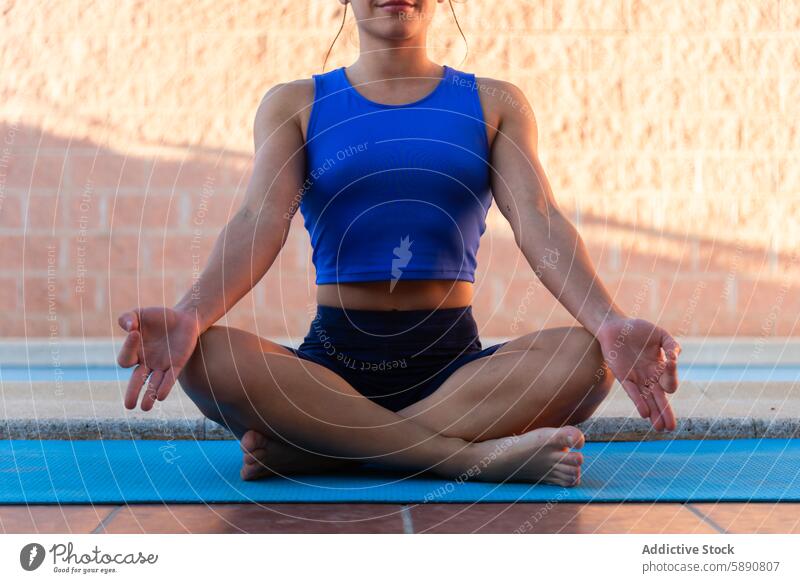 Junge Frau beim Meditieren in der Nähe eines Schwimmbads Yoga Meditation Pool Achtsamkeit Ruhe blau Unterlage Sportbekleidung Fitness Gesundheit Wellness