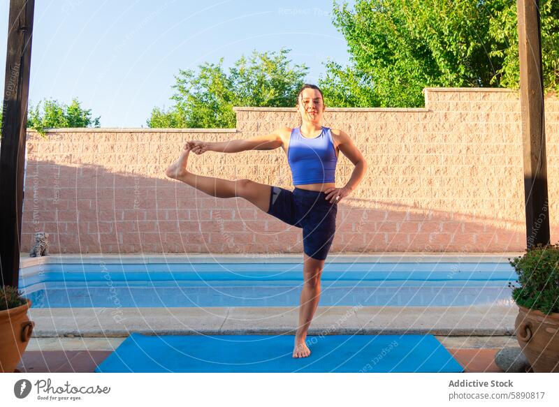 Frau übt Yoga am Pool bei Tageslicht Gleichgewicht Fitness Gesundheit im Freien Übung Ruhe Frieden Erholung Wellness Lifestyle Sport üben Gelassenheit