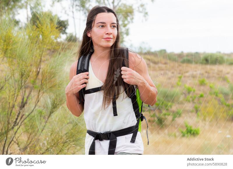 Junge Frau beim Wandern in malerischer Landschaft wandern Abenteuer Rucksack lässig im Freien Natur Wanderung jung Freizeit reisen Entdecker Sommer Grün