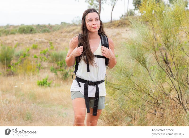 Frau wandert mit einem Rucksack durch die Landschaft wandern im Freien Aktivität Lifestyle trocknen jung lange Haare Abenteuer Sommer Natur reisen Wanderung