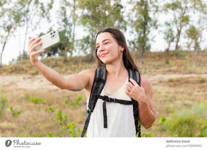 Junge Frau macht ein Selfie beim Wandern in der Natur Wanderer Smartphone im Freien Abenteuer Lächeln Landschaft jung Technik & Technologie Rucksack Sport