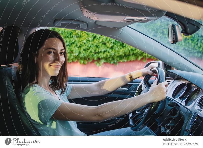 Junge Frau lächelt, während sie ihr Auto fährt Fahrer PKW Fahrzeug lenken Rad Laufwerk Lächeln Glück Sitz Innenbereich Straße Reise reisen Transport Sicherheit