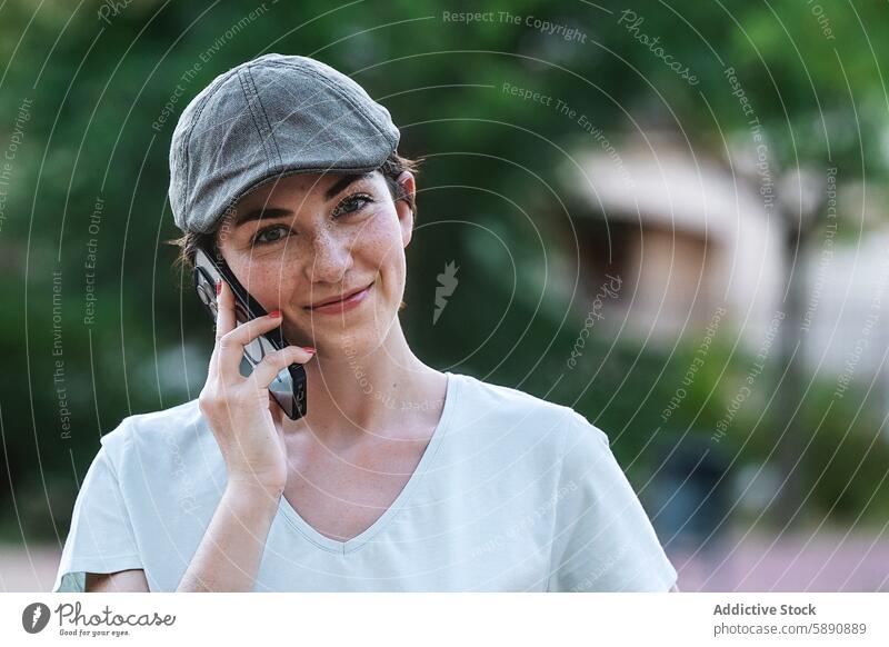 Frau mit Mütze spricht im Freien mit einem Mobiltelefon Smartphone Handy Telefonanruf sprechen reden Technik & Technologie Gerät Apparatur Verschlussdeckel