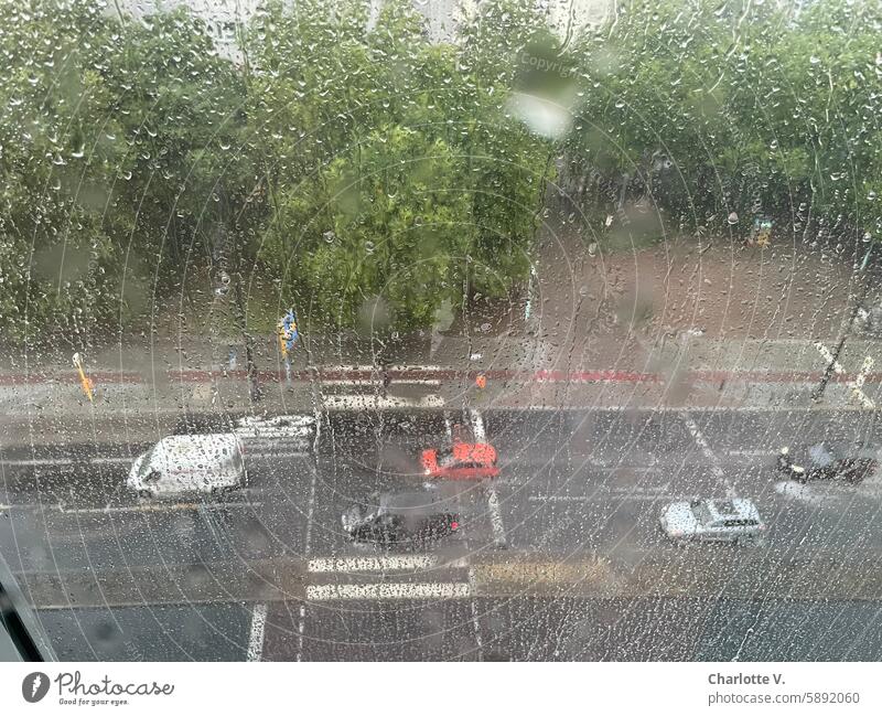 Regentag I Blick durch eine nasse Fensterscheibe auf eine befahrene Straße - Vogelperspektive Regennass regennasse Straße Wassertropfen Wetter Regentropfen